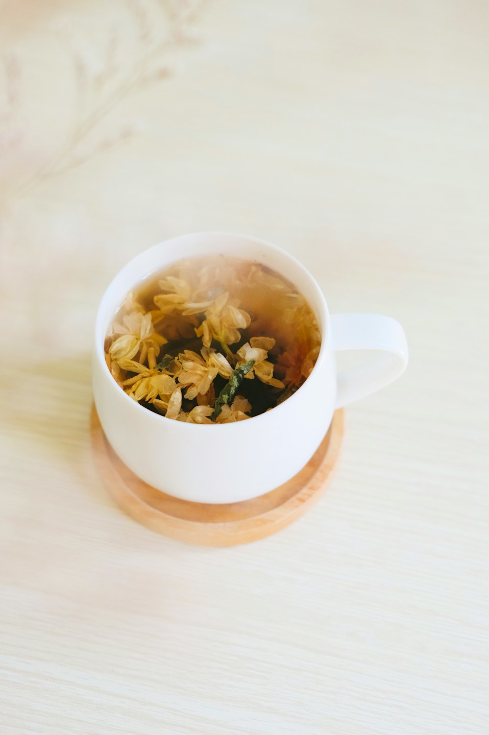 Steaming mug of herbal tea on a wooden surface.
